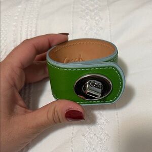Coach leather turnlock cuff bracelet in green.